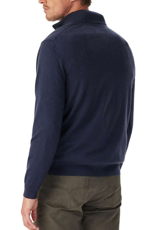 A man in the RM Williams Ernest Merino 1/4 Zip Knit navy sweater and olive green pants is pictured from behind, his head turned slightly to the left.