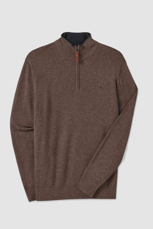 The RM Williams Ernest Sweater, a brown quarter-zip crafted from fine gauge Merino wool, features a dark zipper pull and a mock neck. Its subtle texture is elegantly showcased against a plain white backdrop.