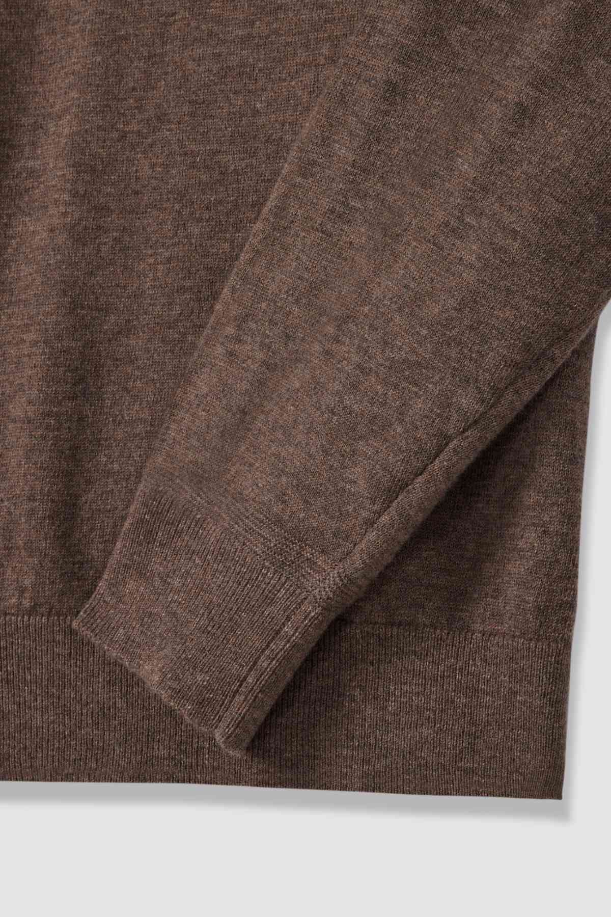 Close-up of the RM Williams Ernest Sweater, a fine gauge merino knit with long sleeves. The fabric appears soft and slightly textured, featuring ribbed cuffs and hem, shown against a neutral background.