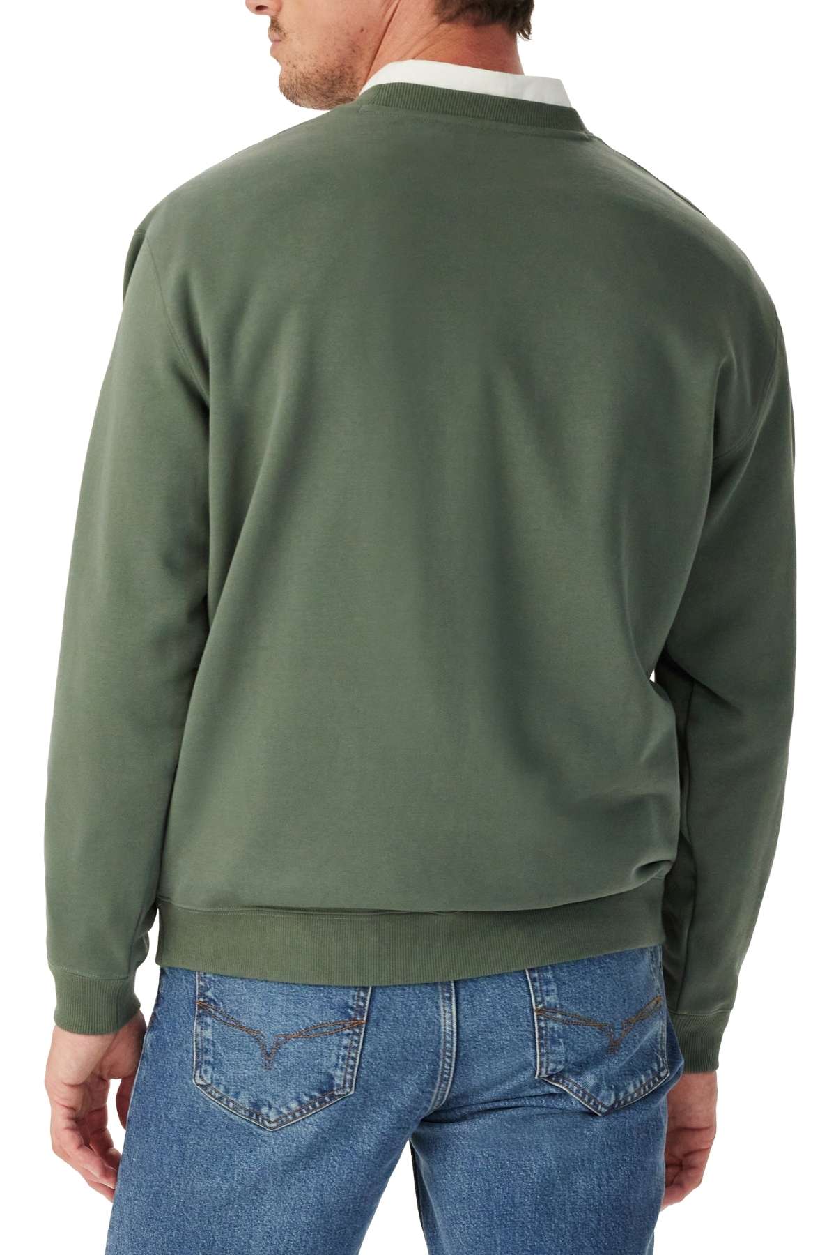 A man is shown from the back wearing an RM Williams Heritage Crew Sweatshirt in green and blue jeans, with his left hand relaxed by his side.
