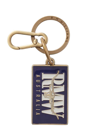 The RM Williams Heritage Logo Enamel Key Ring features a rectangular blue and white enamel tag with "RM WILLIAMS AUSTRALIA" and bull logo, attached to a brass keyring and clasp.