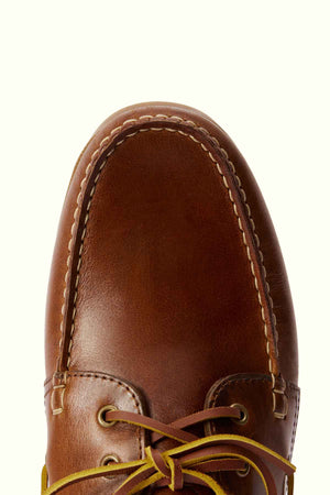 Close-up of the toe and laced area of the RM Williams Islet Moccasin. The moccasin features a smooth, rounded toe with visible stitching along the edges and around the top. The leather laces are partially visible at the bottom of the image.