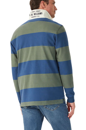 A man wearing the RM Williams Jones Stripe Rugby—an Australian cotton, heavyweight blue and olive green striped shirt with a white twill collar and text on the back of the collar—and blue jeans, shown from behind.