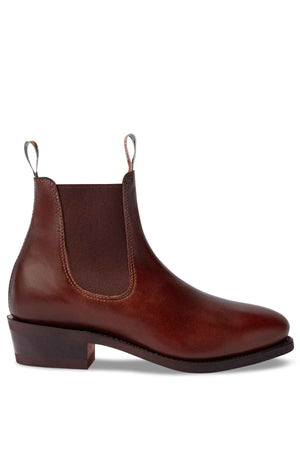 The RM Williams Comfort Lady Yearling Rubber Sole Boot is a single brown leather Chelsea boot, crafted from Spanish pull-up leather. It features elastic side panels, front and back pull tabs, a sleek side profile, and low heel. Handmade in Australia for quality craftsmanship.