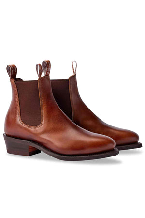 The RM Williams Lady Yearling Rubber Sole Boot in brown Spanish pull-up leather showcases elastic side panels, pull tabs, a rounded toe, and stacked wooden heel on a plain white background.
