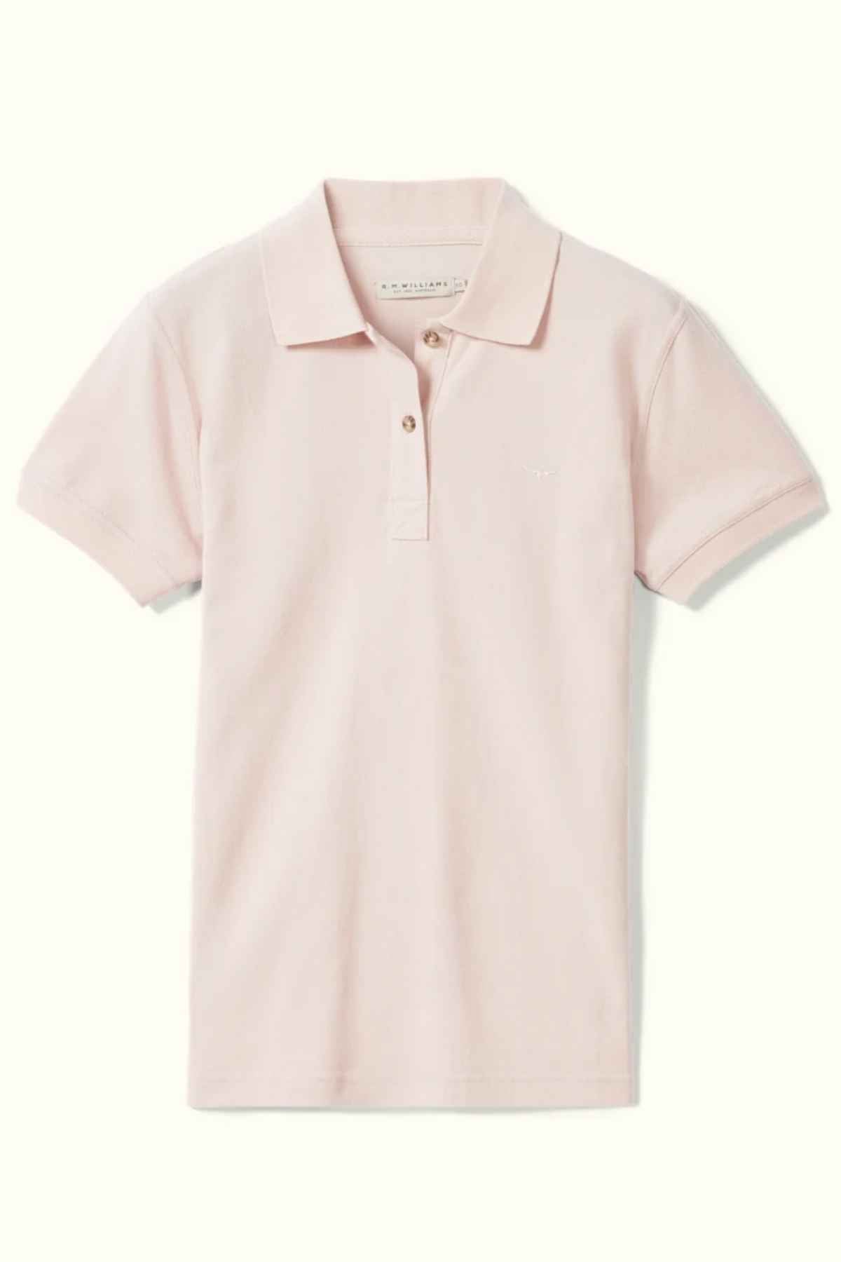 The RM Williams Margaret Polo is a light pink shirt made of pique cotton, featuring a ribbed collar, short sleeves, and two neckline buttons, displayed on a neutral background.