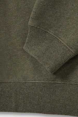 Close-up of the RM Williams Mini Longhorn Sweatshirt's sleeve and bottom hem. The fabric appears to be knitted, with ribbed cuff and hem providing a textured look. Made from recycled cotton poly fleece, its earthy olive green hue gives it an eco-friendly charm.