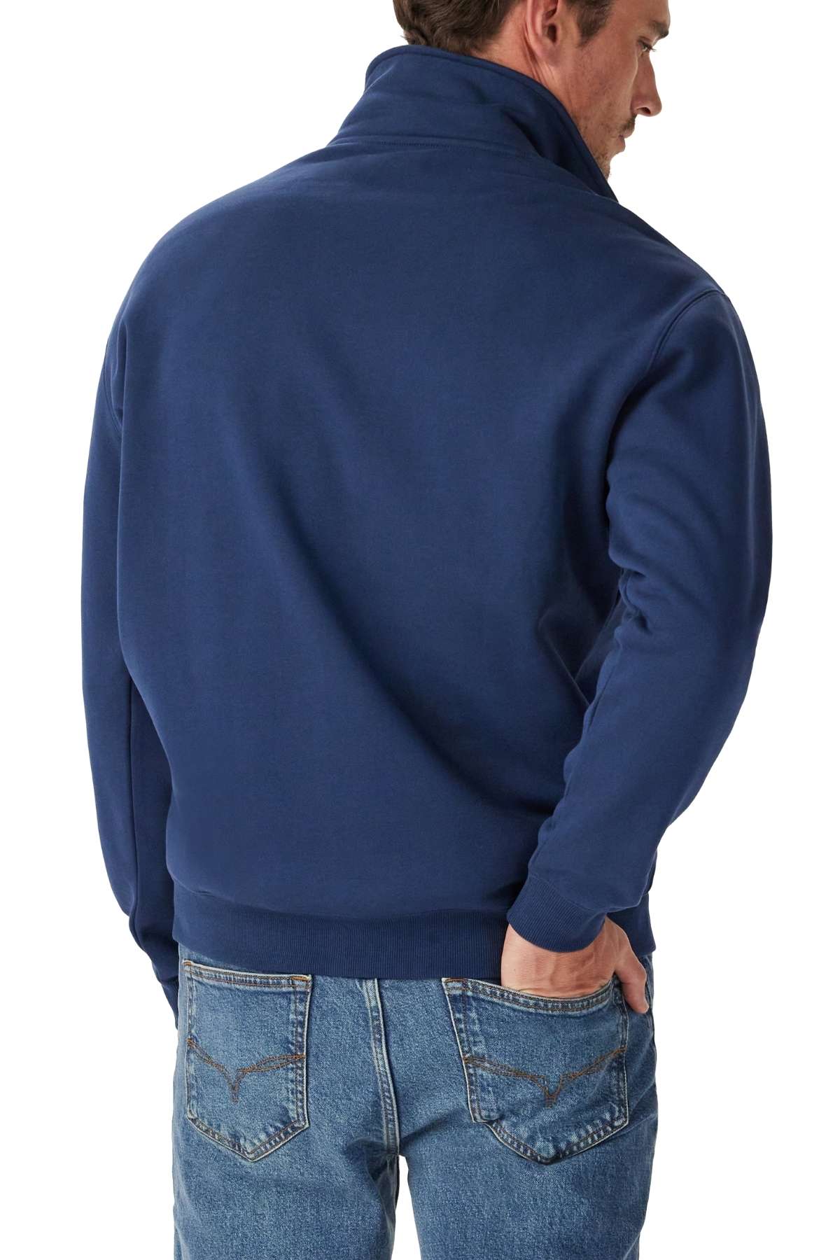 A man wearing an RM Williams Mulyungarie 1/4 Zip Sweatshirt stands with his back to the camera, one hand in his back pocket.