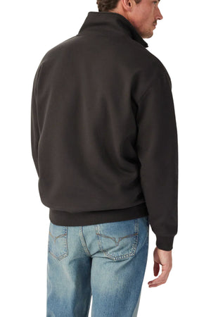 A man with short brown hair is seen from behind wearing the RM Williams Mulyungarie 1/4 Zip Sweatshirt in black and light blue jeans, standing against a white background.