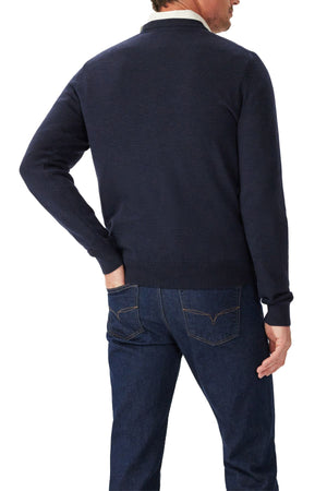 A man is seen from behind wearing the RM Williams Murphy Merino Crew Knit in dark navy with blue jeans, one hand in his back pocket, standing against a plain white background.