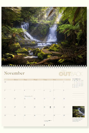 The November page of the RM Williams Outback Calendar 2025 showcases lush forests and cascading waterfalls by Australian photographers, with a day grid below and a thumbnail of the main image in the corner of this stunning wall calendar.