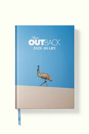 The RM Williams Outback Diary 2025 is a hardcover planner with a blue cover showing an emu on sand beneath a clear sky, with “R.M. Williams OUTBACK 2025 DIARY” in white and light blue lettering on the front.