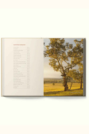 The RM Williams Outback Diary 2025 features 2023 public holidays on the left page and a photo of a sunlit tree in an Australian landscape on the right, providing perfect inspiration for your planning.