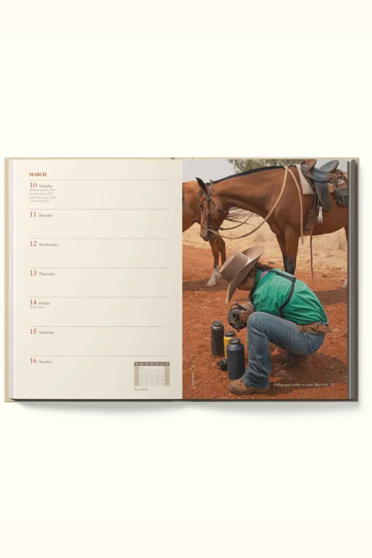 A person in a cowboy hat kneels by a saddled horse, pouring a drink from a thermos. The left page shows a March weekly planner in the durable hardcover RM Williams Outback Diary 2025, featuring striking Australia photos.