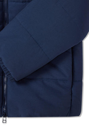 Close-up of the RM Williams Padstow Jacket sleeve in navy blue, crafted from recycled nylon. It features a front zipper, quilted stitching, and an elastic cuff with thick Primaloft fill for winter warmth.