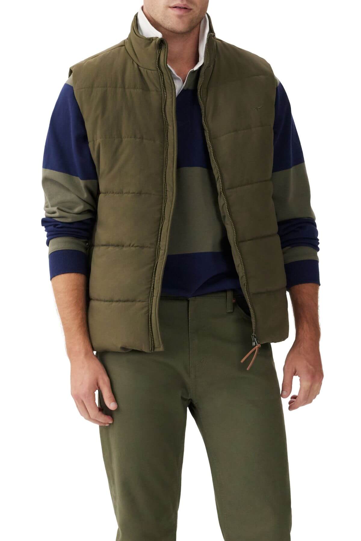 A person wearing an RM Williams Padstow Vest in green with PrimaLoft filling over a green and navy striped long-sleeve shirt. They are also dressed in green pants and posed against a plain white background.