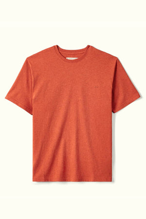 The RM Williams Parson T-Shirt is a plain, short-sleeve crew neck shirt in terracotta, crafted from soft organic cotton and featuring a subtle embroidered logo on the left chest against a light background.