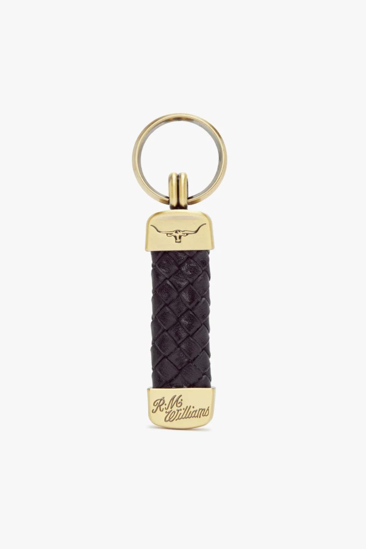 The RM Williams Plaited Key Ring is made of woven black kangaroo leather with brass-toned metal accents, featuring a longhorn embossed logo on top and "R.M. Williams" engraved at the bottom. It includes a round metal keyring.