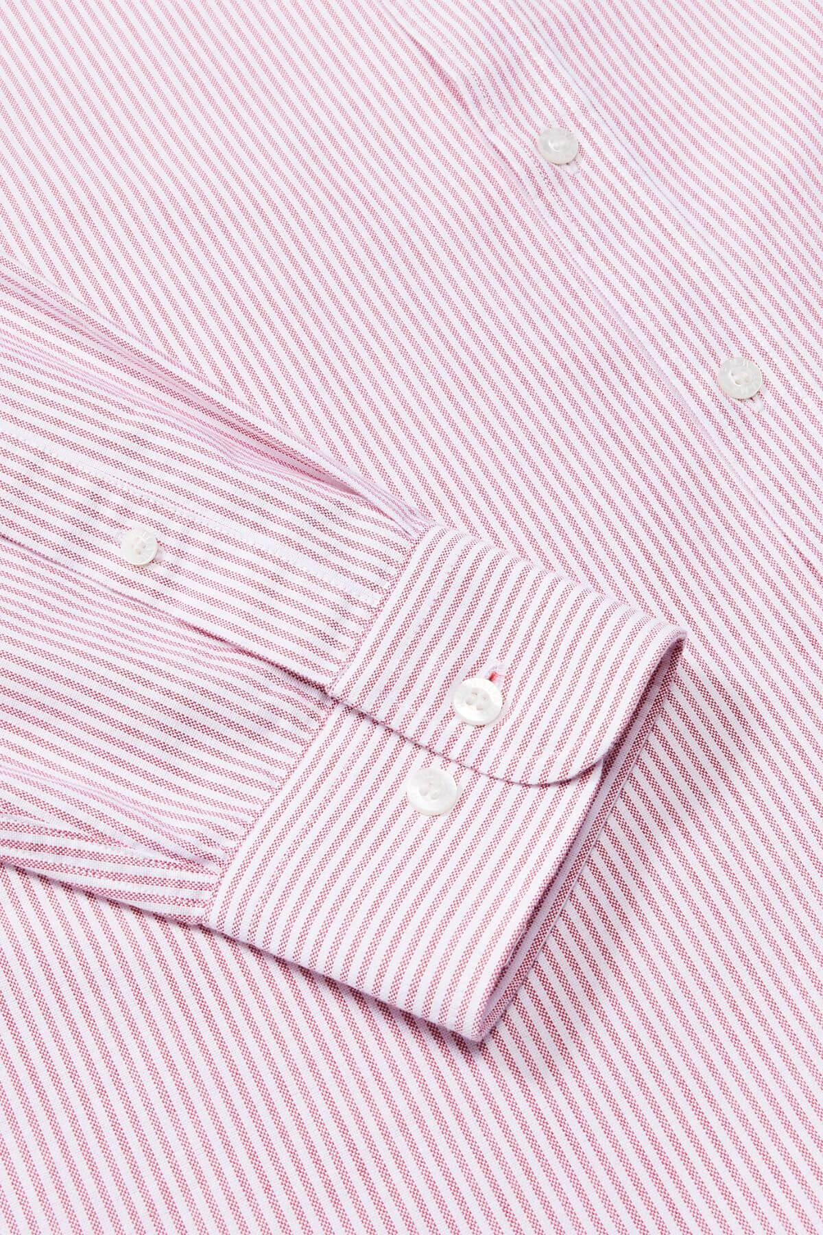 A close-up of the RM Williams Regular Shirt, a slim fit long-sleeve dress shirt with thin pink and white vertical stripes, made from organic cotton and detailed with white buttons on the cuff and front.
