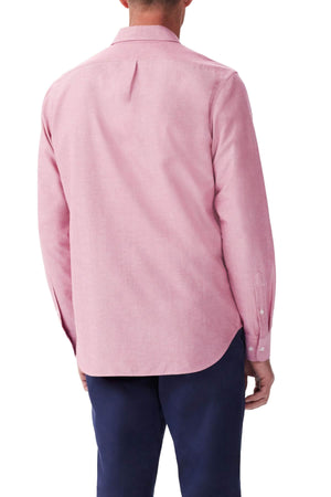 A man is shown from the back, wearing a light pink RM Williams Regular Shirt and dark blue pants.