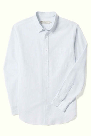 The RM Williams Regular Shirt is a light blue, long-sleeve dress shirt adorned with a subtle vertical stripe pattern. Crafted from striped oxford cotton, it features a button-down front and a pocket on the left side. This shirt also boasts a classic collar and buttoned cuffs, designed in a slimmer cut that stands out against the plain white background.