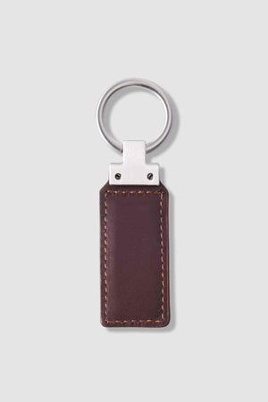 A rectangular brown leather RM Williams Ridgewood Key Fob with visible stitching and a silver metal ring, shown on a light gray background.