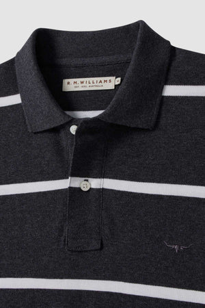 The RM Williams Rod Polo is a black and white striped cotton shirt with a collar, buttons, and small longhorn embroidery on the chest. The label inside the collar reads "R.M. Williams.