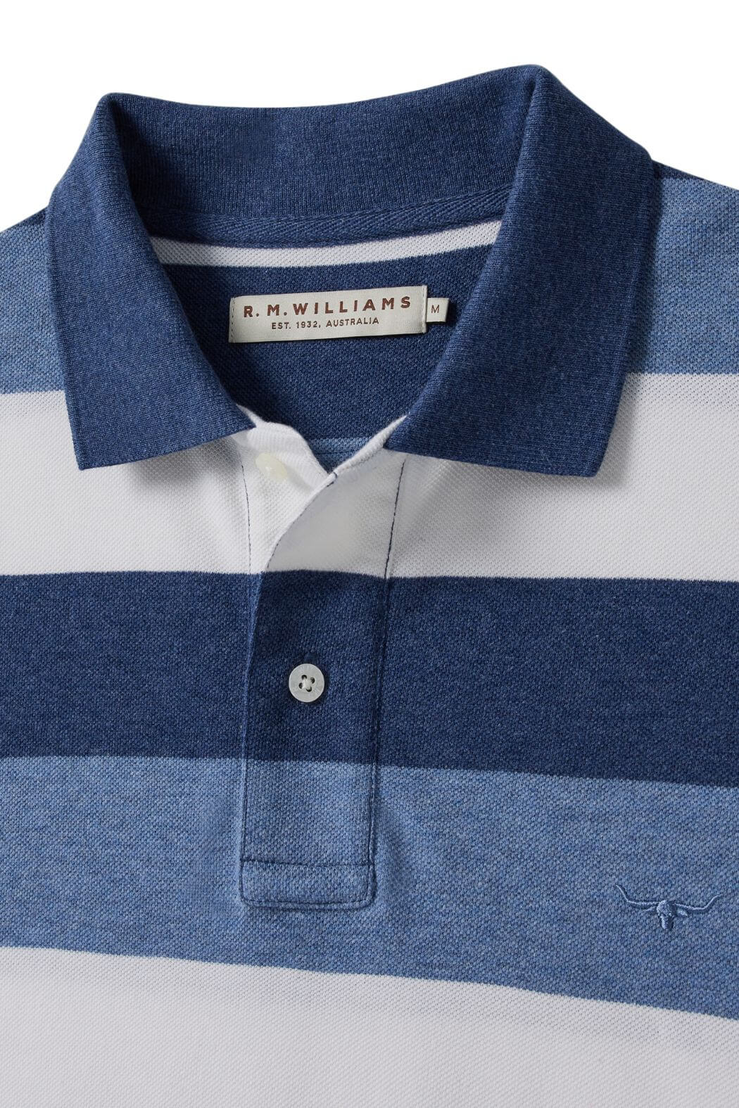 A close-up of the RM Williams Rod Polo, made from cotton pique with navy, white, and light blue stripes. Features a collar, two-button placket, R.M. Williams label inside the collar, and signature longhorn embroidery.