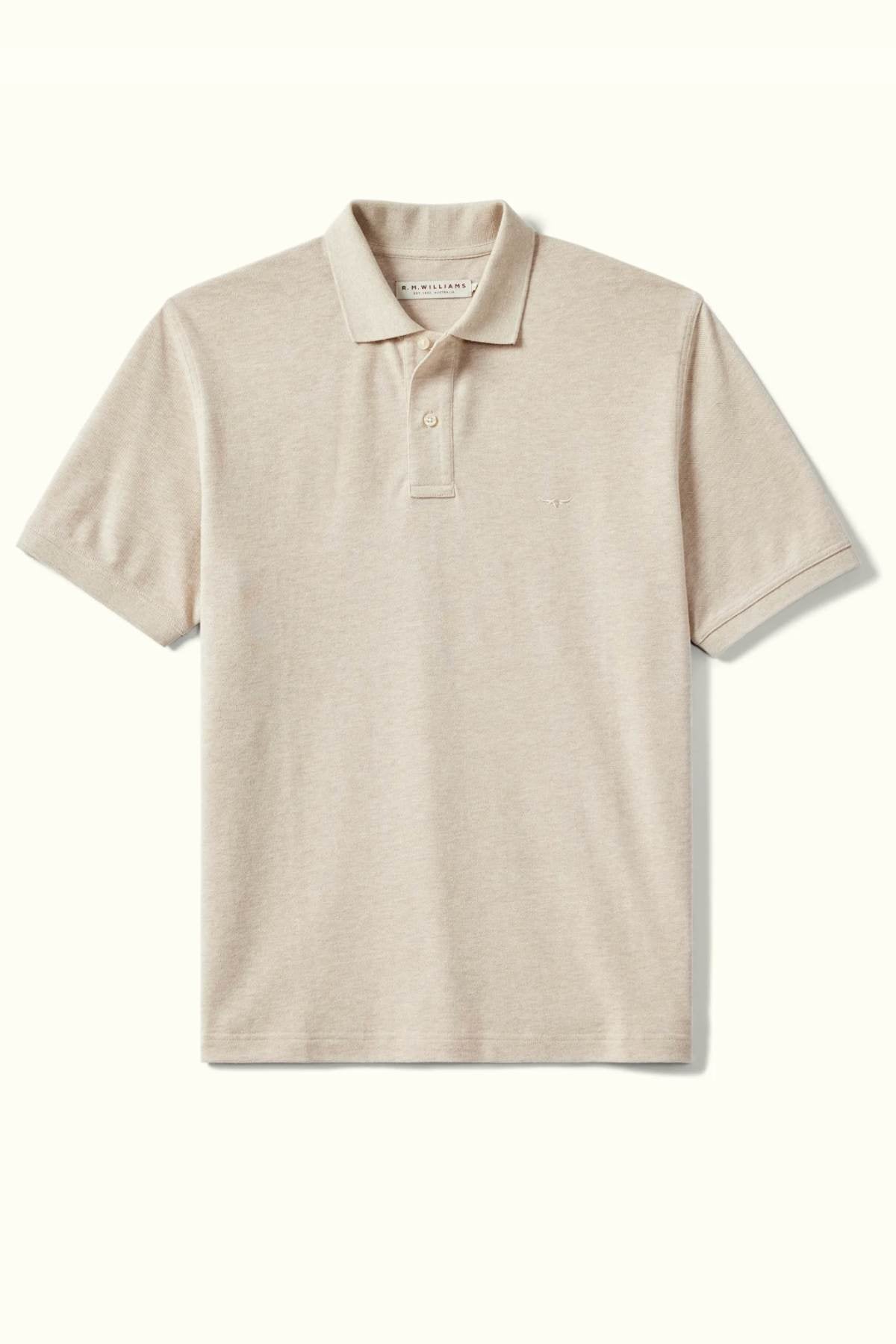 The RM Williams Rod Polo is a beige shirt designed in breathable cotton pique, featuring a classic collar and short sleeves. Displayed against a light backdrop, it includes a two-button placket and subtle embroidered logo, providing a classic fit.