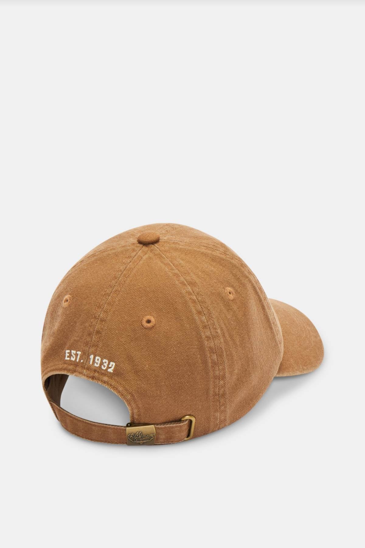 The RM Williams Script Longhorn Cap is a brown baseball cap made from washed cotton twill, featuring "EST. 1938" embroidered on the back. It includes an adjustable strap with a brass buckle to ensure a perfect fit.