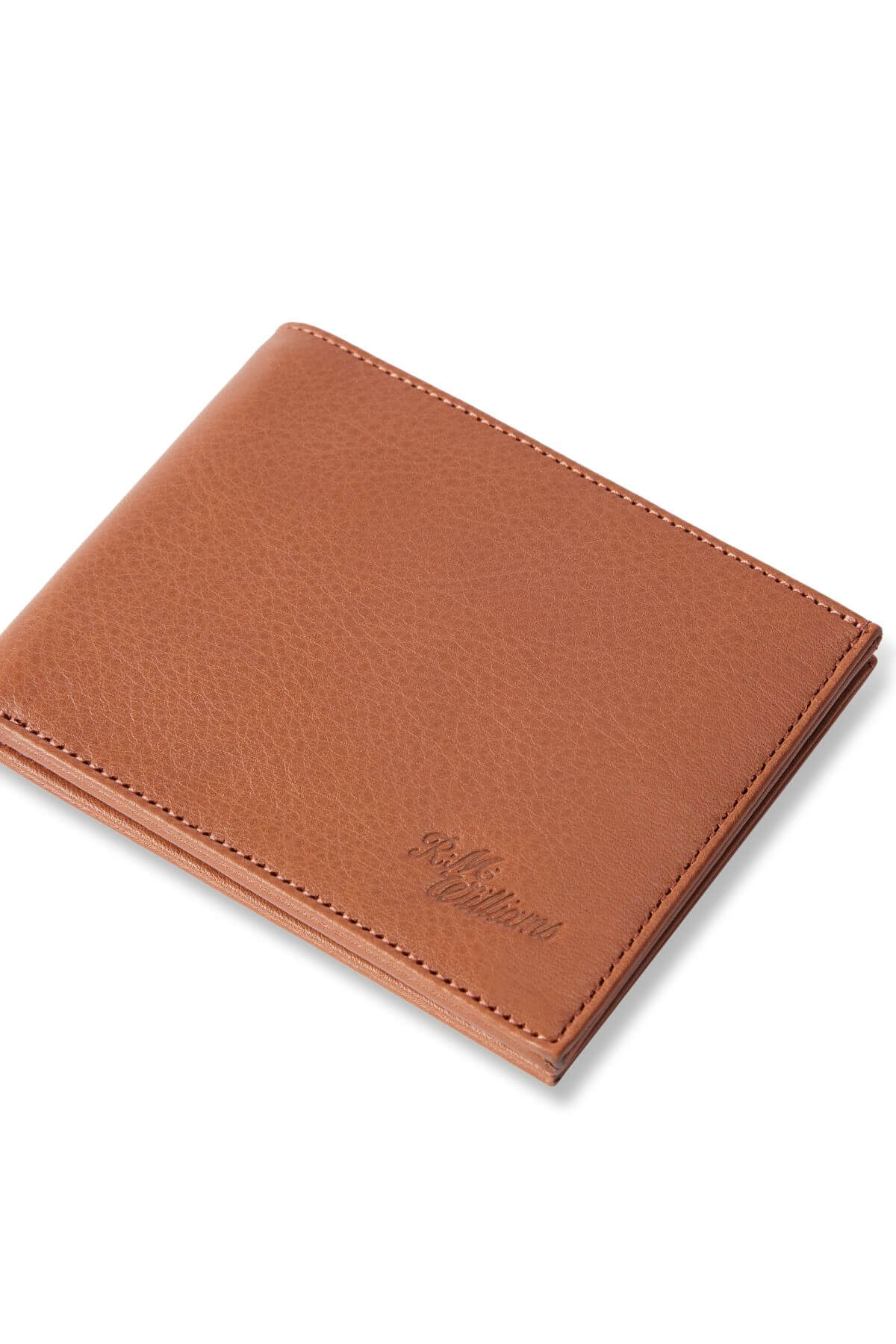 The RM Williams Singleton Bi-fold Wallet is a slimline wallet made from premium natural milled leather with a textured finish, neat edge stitching, and a small embossed logo in the corner. It features RFID protection for style and security against a crisp white background.