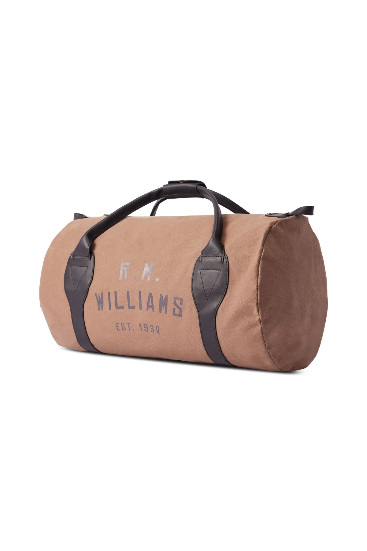 The RM Williams Sorrento Ute Bag is a tan canvas cylindrical duffel with black handles, leather trims, a top zipper closure, and "R.M. Williams Est. 1932" in gray on the side. Made in Australia.