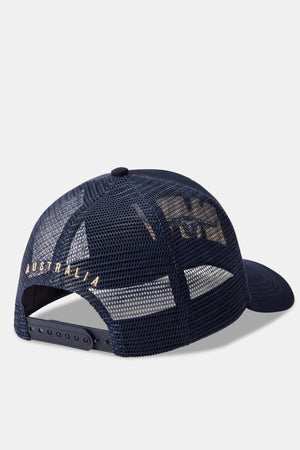 Introducing the RM Williams Steers Head Trucker Cap: A stylish navy blue mesh cap with an adjustable snapback closure, adorned with "Australia" embroidered in elegant gold lettering on the back.