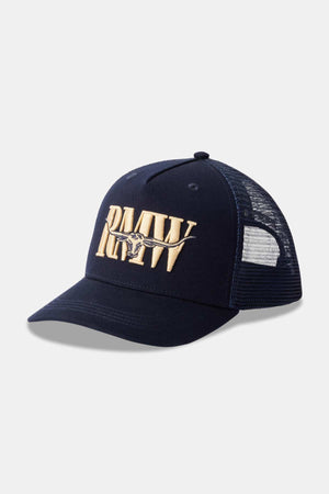 The RM Williams Steers Head Trucker Cap is a navy blue cap featuring an adjustable snapback and mesh back. The front of the cap is adorned with a gold embroidered "RMW" logo complemented by a horn design across it.