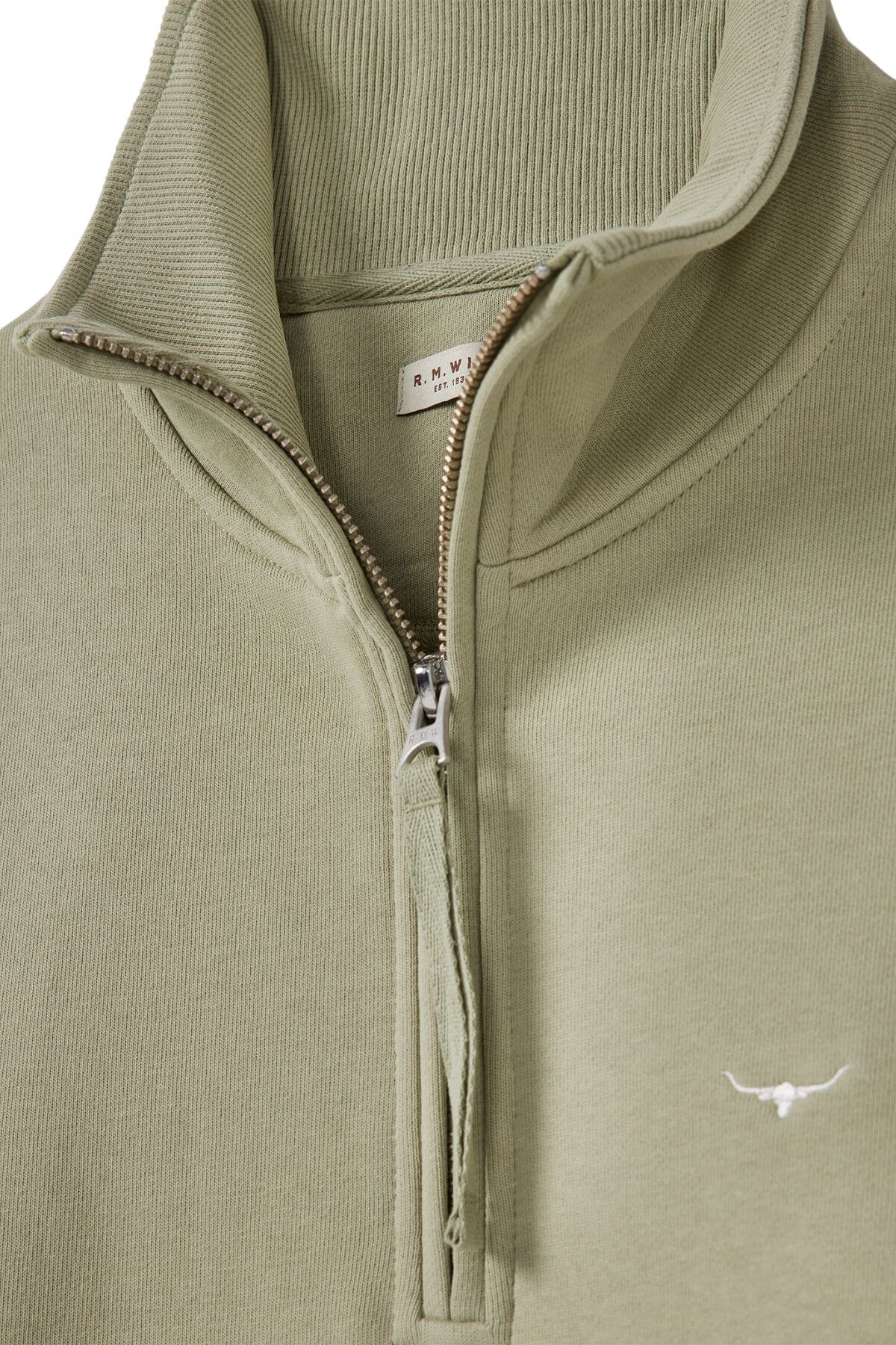 A light olive green RM Williams Trickett Zip Neck Sweatshirt in cotton terry, featuring a high collar, half-zip design, and subtle white longhorn embroidery on the lower front.
