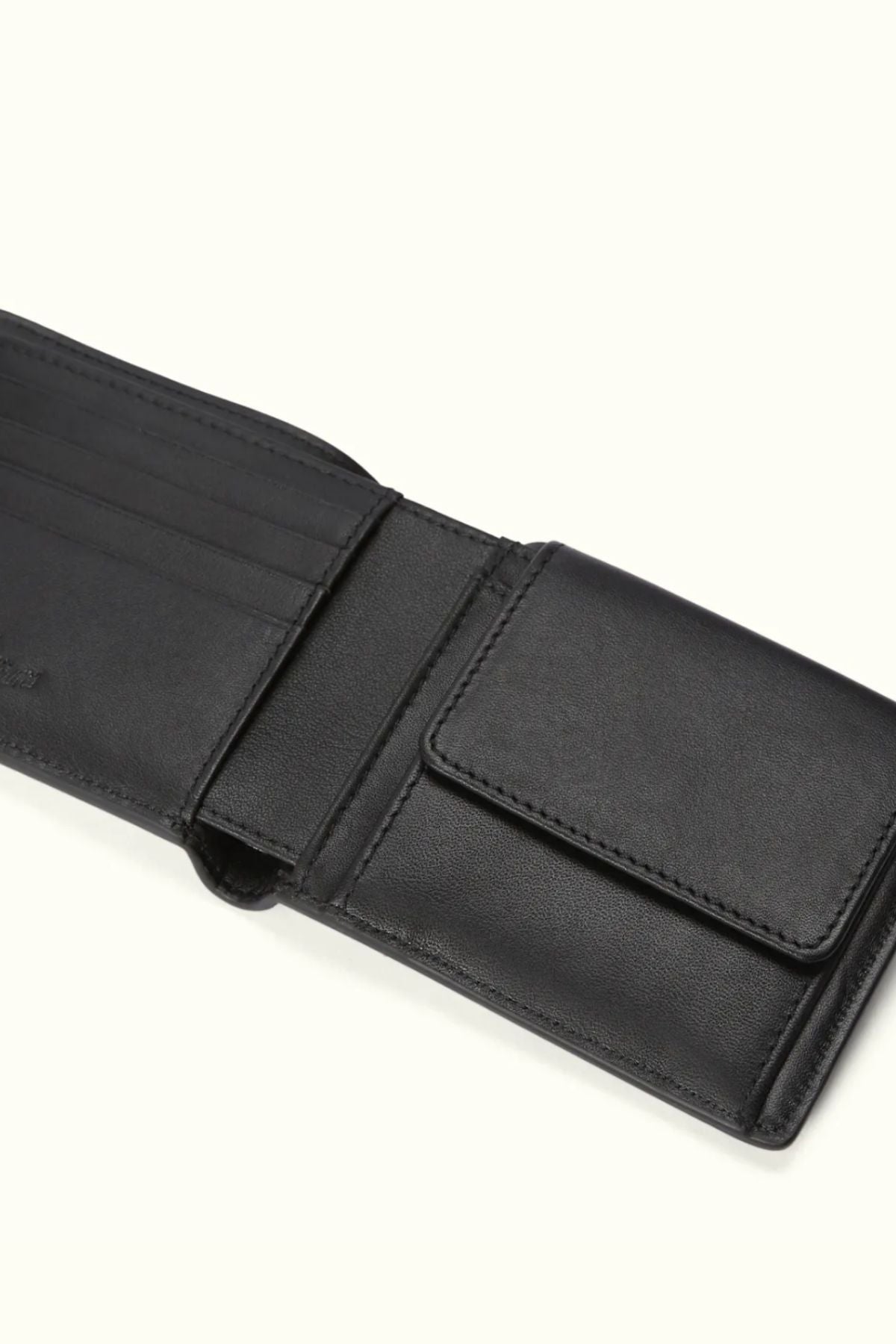 The RM Williams Wallet with Pocket and Tab in black is open to reveal multiple card slots on the left and a coin pocket with flap on the right, displayed against a light background.