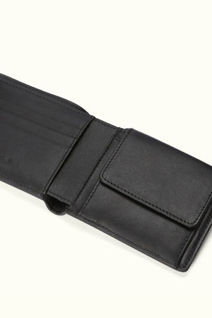 The RM Williams Wallet with Pocket and Tab in black is open to reveal multiple card slots on the left and a coin pocket with flap on the right, displayed against a light background.