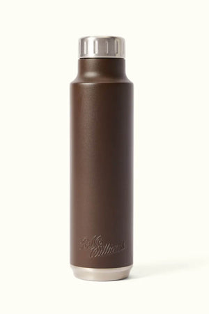Introducing the RM Williams Water Bottle: a stylish brown stainless steel bottle with a silver cap, featuring a sleek, BPA-free design. Its vacuum-insulated construction ensures your beverages remain at the ideal temperature. The bottle is elegantly finished with an embossed logo at the base, set against a smooth, light surface.