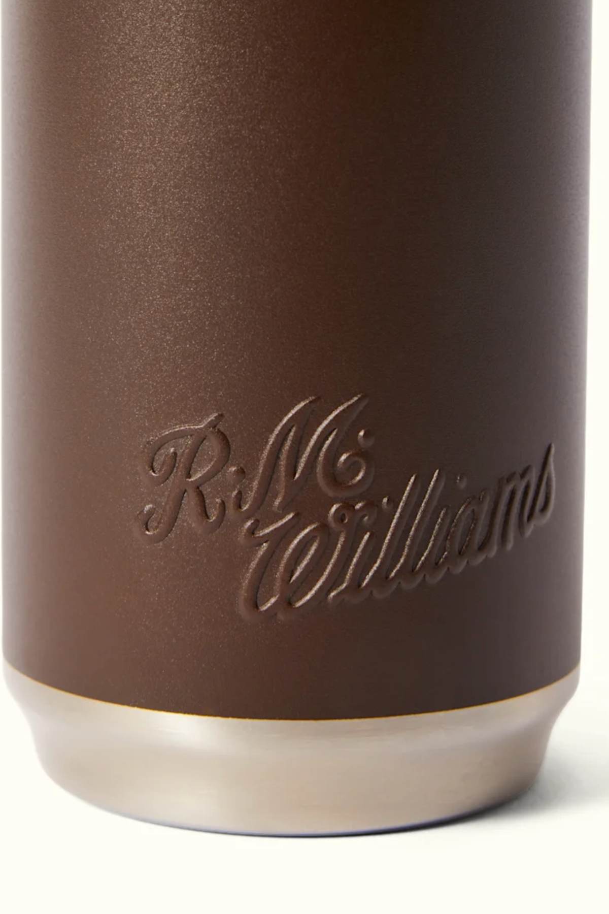 A detailed view of a brown leather texture displaying the elegantly scripted "R.M. Williams" logo at the bottom evokes the precision and craftsmanship found in the RM Williams Water Bottle, known for its BPA-free, vacuum-insulated stainless steel design.
