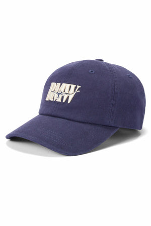 The RM Williams Heritage Twill Cap is a navy blue organic cotton cap with "PARTY" and "RCTV" embroidered in white, plus a jumping person graphic on the front. It features an adjustable strap for comfort and style.