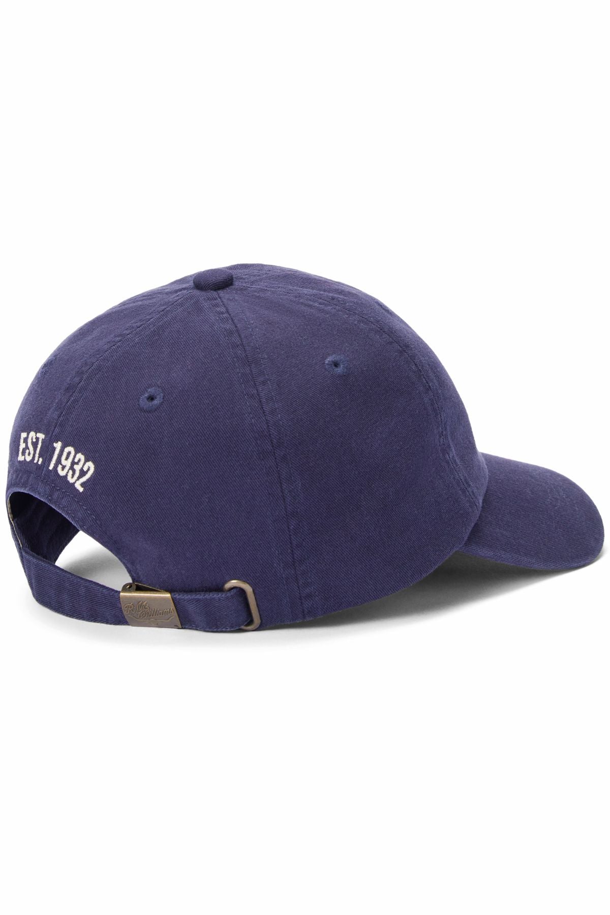 The RM Williams Heritage Twill Cap in navy blue is shown from the back, featuring white "EST. 1932" embroidery above an adjustable strap with a metal buckle.