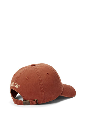 The RM Williams Heritage Twill Cap in rust displays the heritage logo from the back, featuring an adjustable strap and white "EST. 1932" embroidery above the opening.