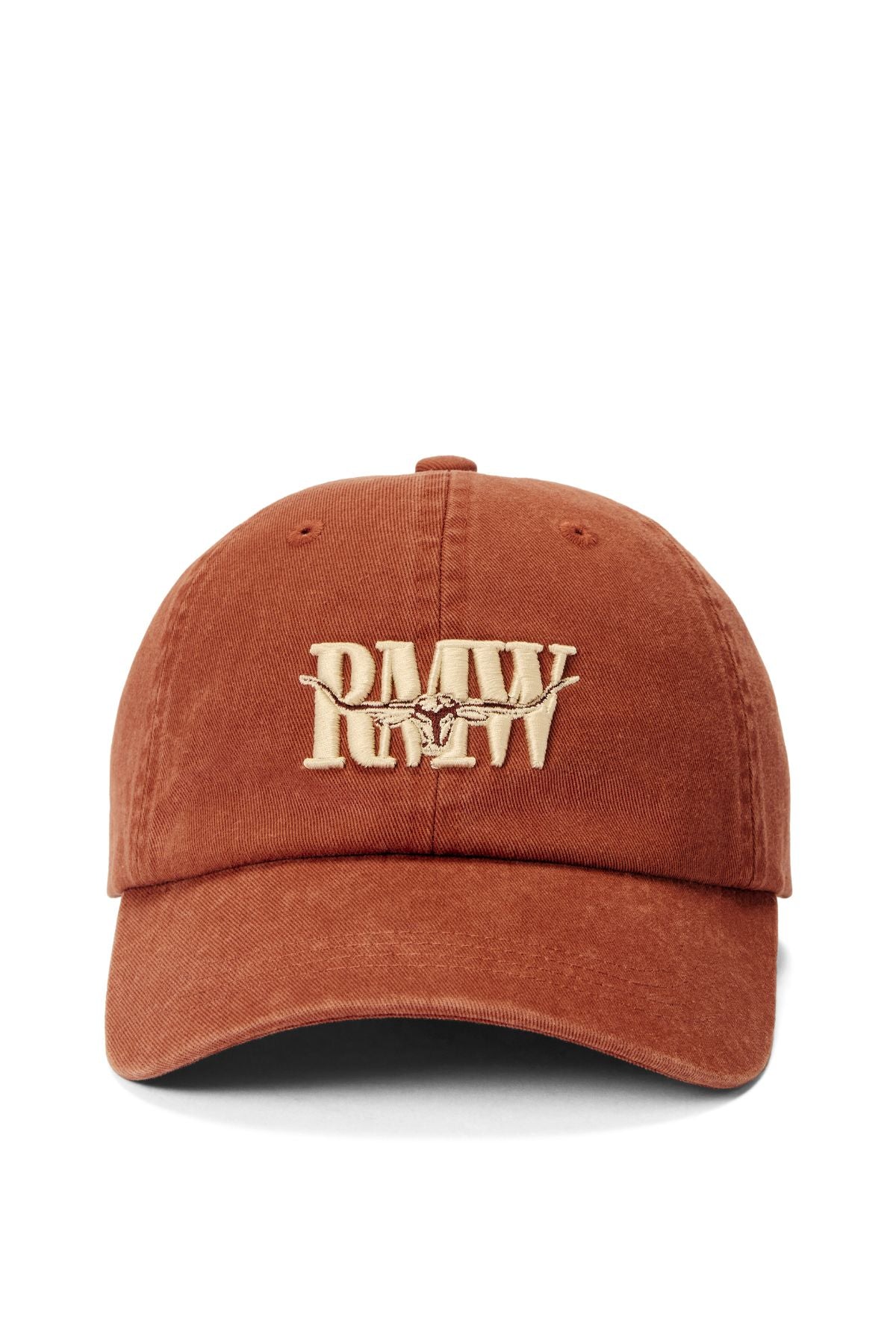 The RM Williams Heritage Twill Cap is rust-colored with large beige "PMW" embroidery and a small cow motif on the front. Made from organic cotton, it features an adjustable strap for a custom fit.