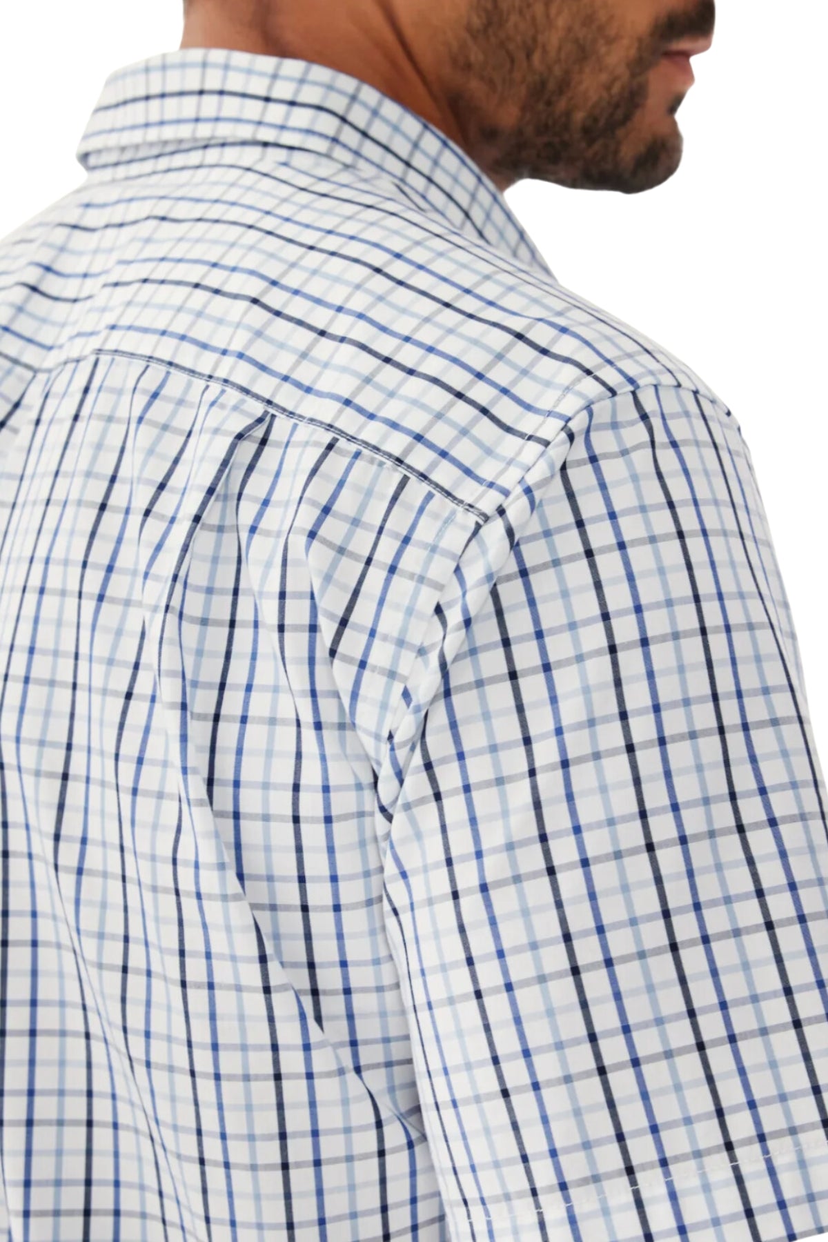 Close-up of a man's shoulder and part of his face, wearing the RM Williams Hervey Shirt in white with blue and black checks. The image highlights its breathable cotton fabric plus detailed back, collar, and sleeve seams.