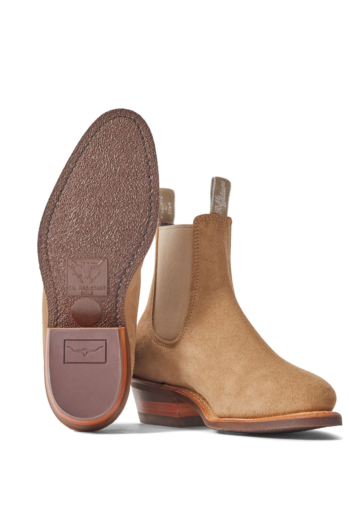 The RM Williams Comfort Lady Yearling Suede Rubber Sole Boot in tan features brown side panels and leather soles; one boot stands upright showing its side, the other displays the textured sole with logo and heel detail.