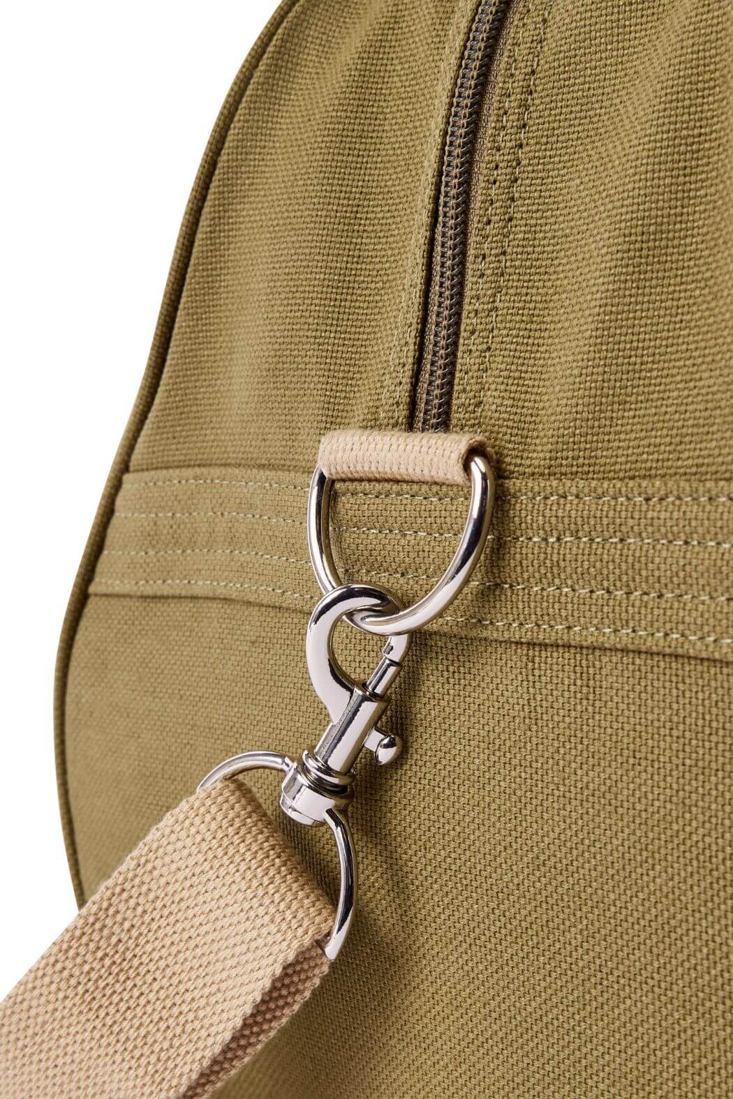 Close-up of the RM Williams Nanga Canvas Bag in khaki, showing its sturdy beige strap with a silver clasp and D-ring by the zipper. The durable cotton canvas texture and detailed stitching are clearly highlighted.