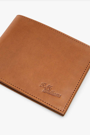 The RMW Singleton Wallet with Coin Pouch, a brown RFID-protected accessory made from calf leather, showcases a stitched edge and an embossed logo at the lower corner as it rests elegantly against a white background.