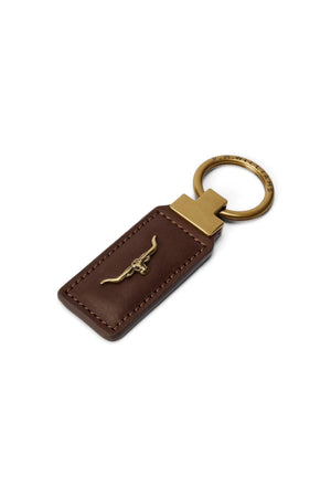 The RM Williams Angaston Key Fob is a brown leather keychain featuring a gold split keyring and a gold longhorn emblem elegantly embossed on the leather.