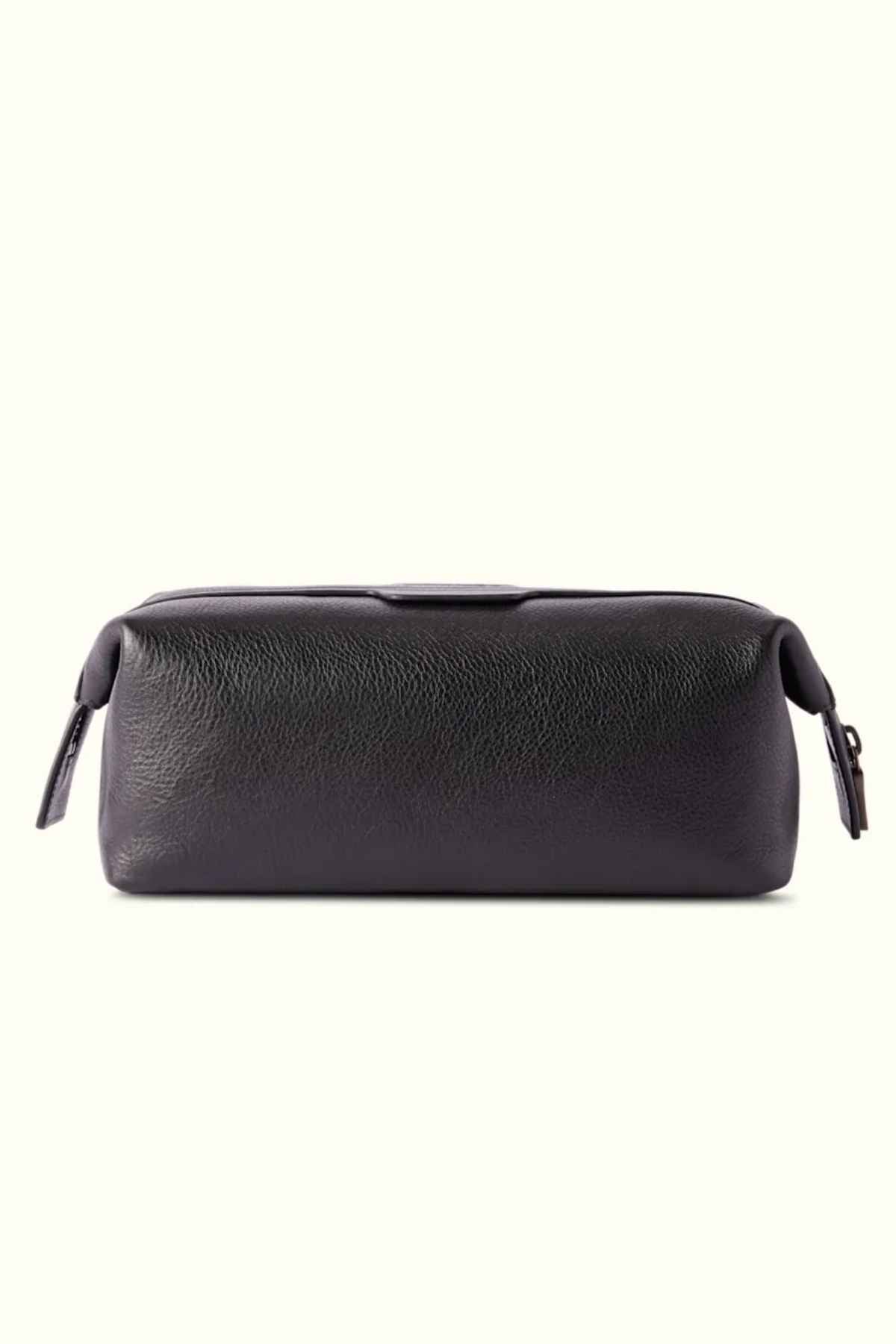 The RM Williams Farrier Washbag is crafted from dark leather with a textured finish. It features a frog-mouth zipper and two zipper pulls on each end. Its rectangular design makes it ideal for storing toiletries or small items, offering a blend of style and functionality.