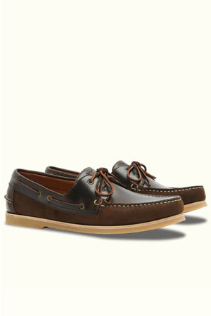 The RM Williams Hobart Boat Shoe features brown bovine leather, tan rubber soles, brown leather laces, and decorative moccasin-style stitching along the toe and sides, displayed on a light background.